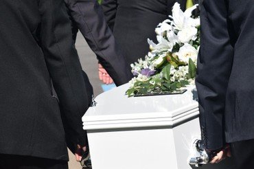 Billede fra en begravelse. En kiste der bæres ud.